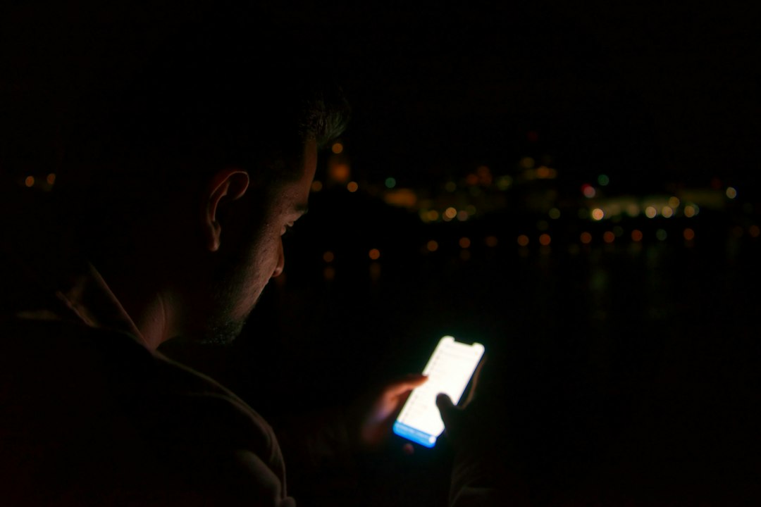 Man holding a glowing smartphone at night