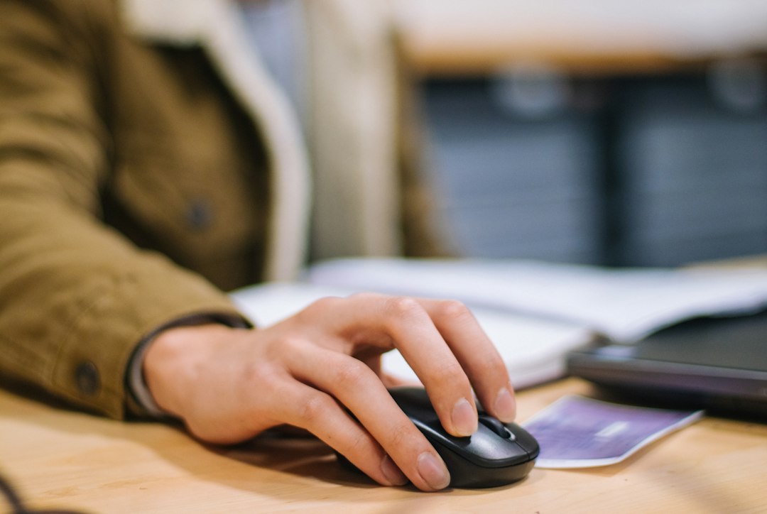 A hand on a mouse, sleeve pulled down, which is the surface a heated pad is actually trying to fix.
