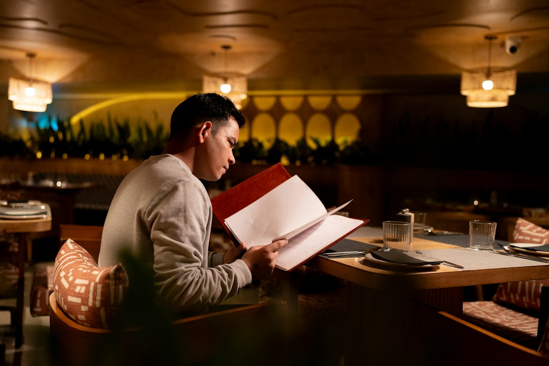 Man reading a restaurant menu at his table