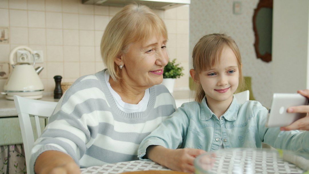 Grandmother and granddaughter taking a selfie together on a tablet