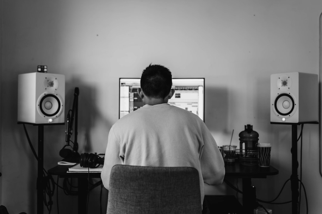 Person listening at a desk between two speakers