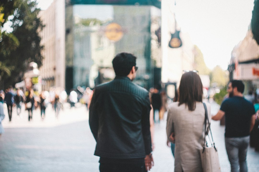 Pedestrians walking a busy city sidewalk, the kind of place open-ear audio is meant for