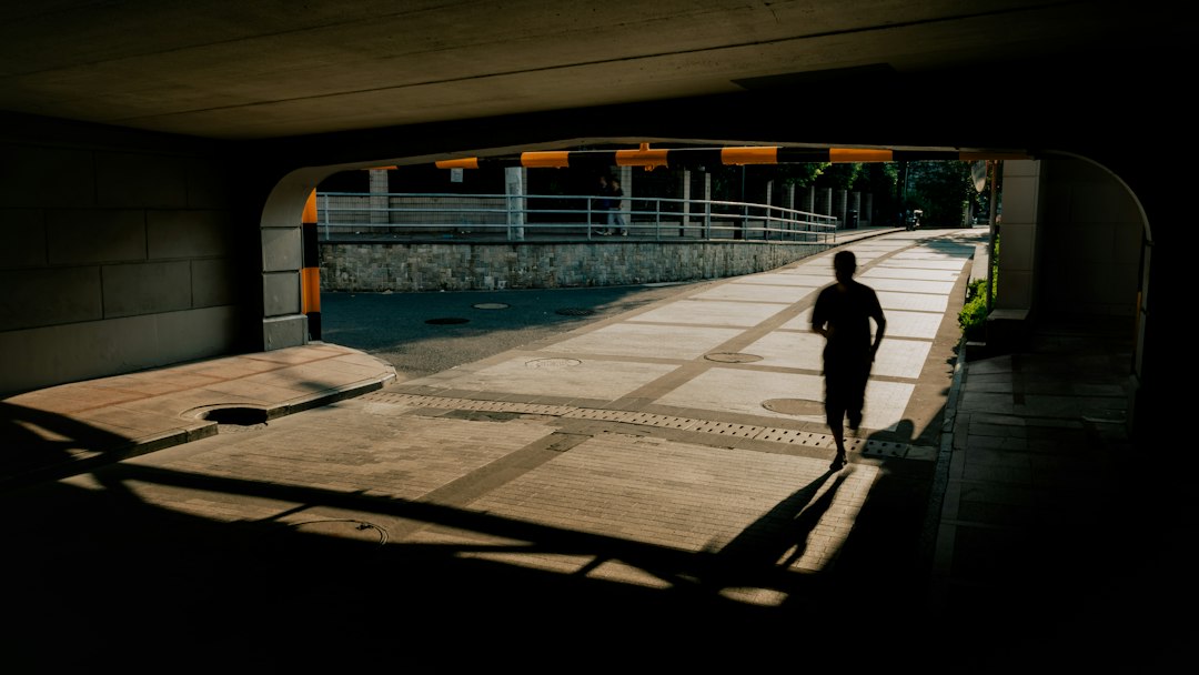 A runner moving through a sunlit urban underpass