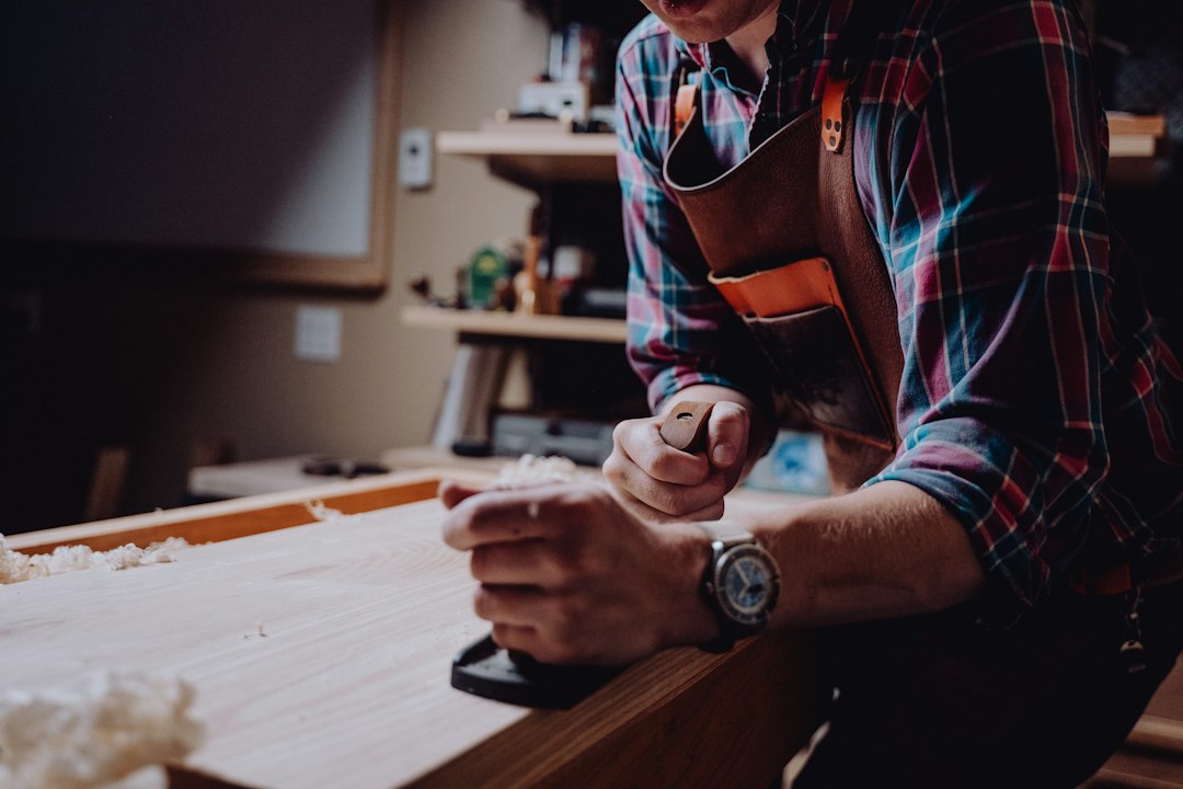 Craftsman in a leather apron working with hand tools at a wooden workbench