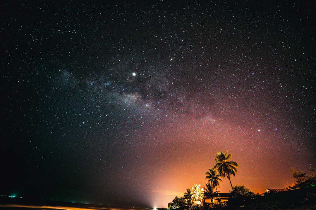 The Milky Way arching over a dark landscape far from city lights