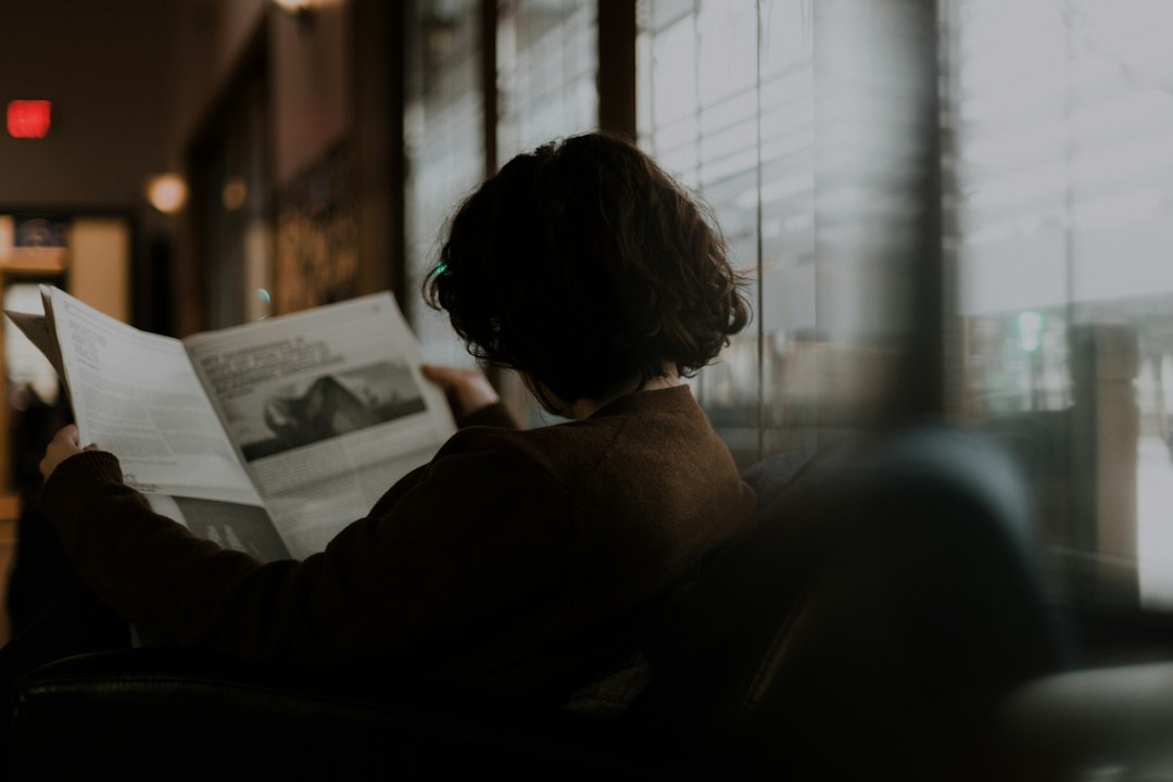 A person reading in dim, warm indoor light