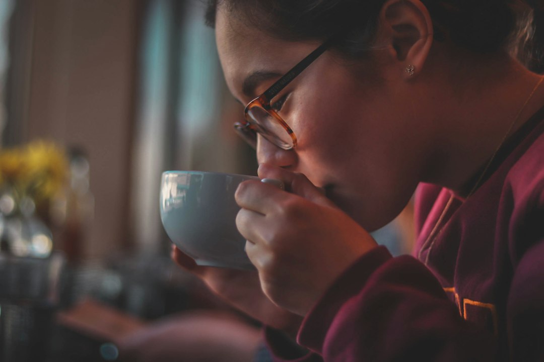 A person having coffee indoors in warm morning light