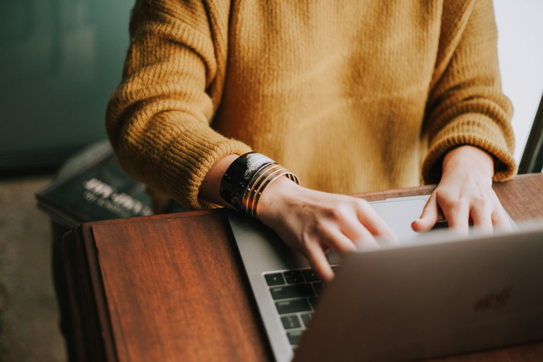 A person in a thick knit sweater working on a laptop, the usual first response to a cold office.