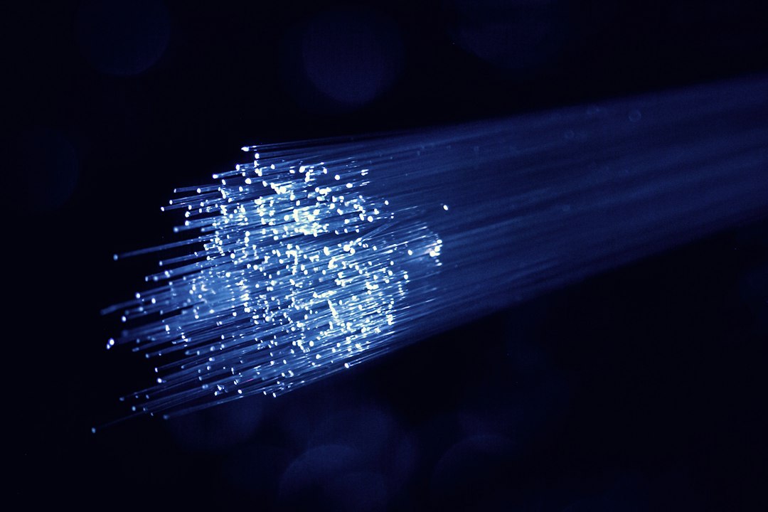 Bundle of illuminated fiber optic strands against a dark background