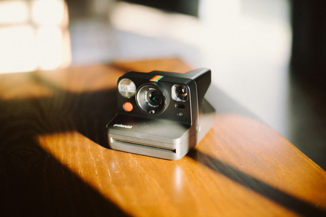 An instant camera sitting on a wooden table