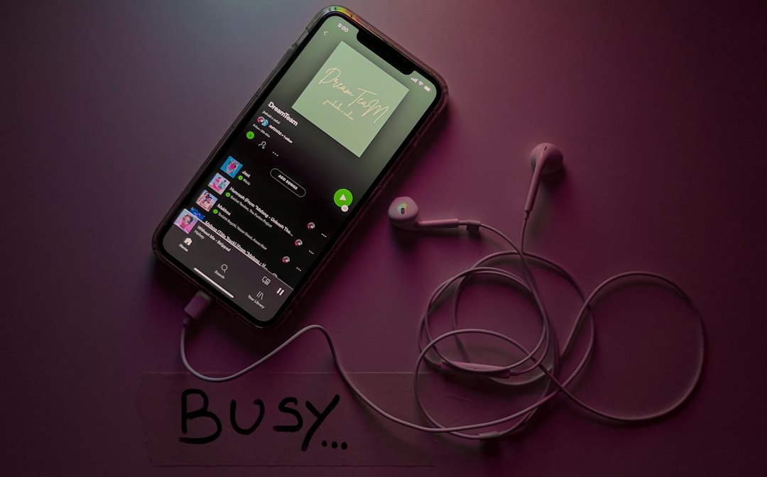Phone with wired earbuds connected showing a music streaming app