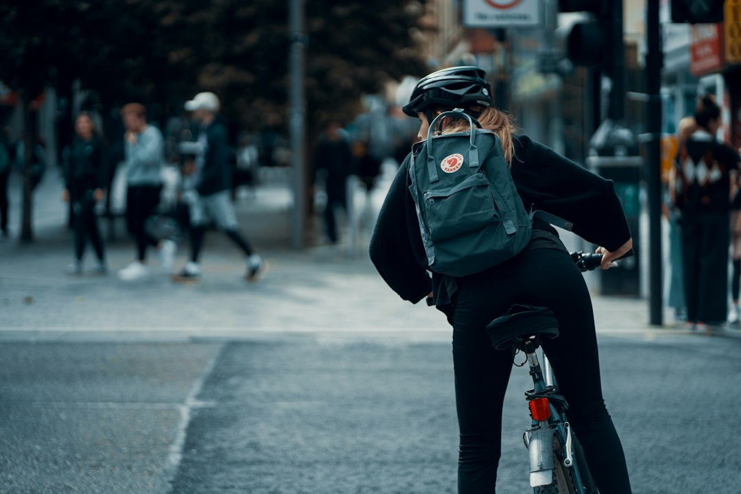City cyclist in a black helmet waiting at an intersection