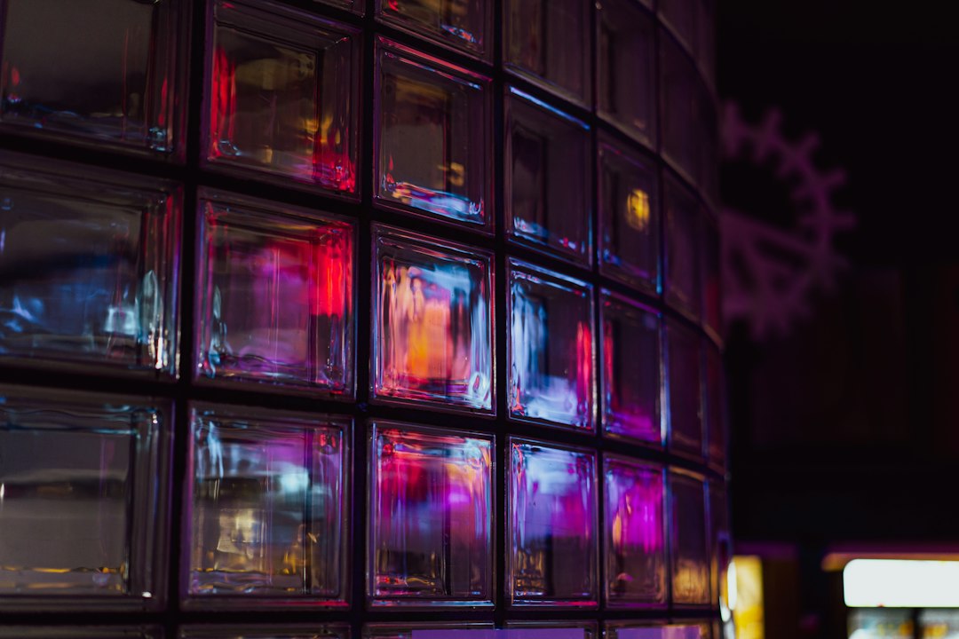 Colorful light reflections across a glass block wall