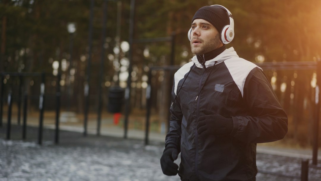A runner outdoors wearing large over-ear headphones
