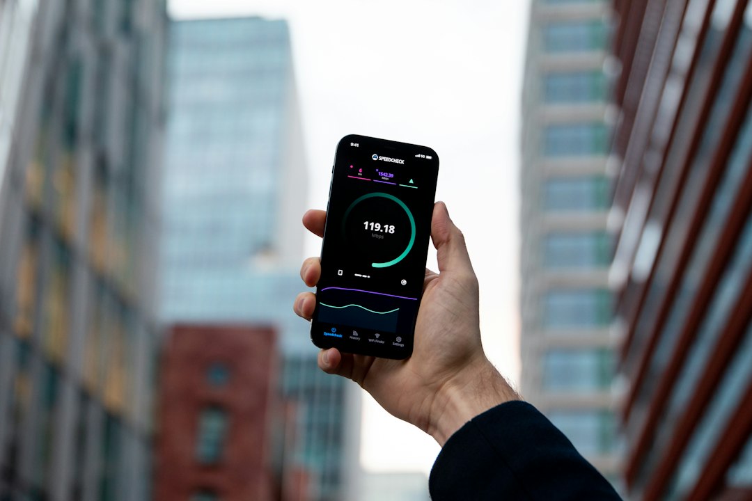 Hand holding a phone running a network speed test showing the download result