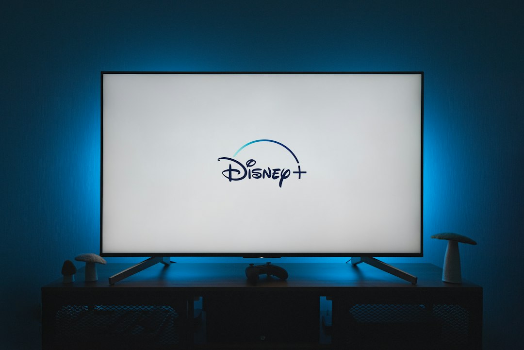 Television glowing in a dark room, screen light washing a deep blue wall at night