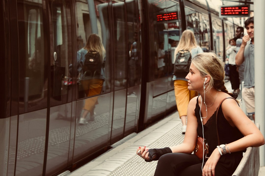 Commuter wearing wired earbuds at a train station