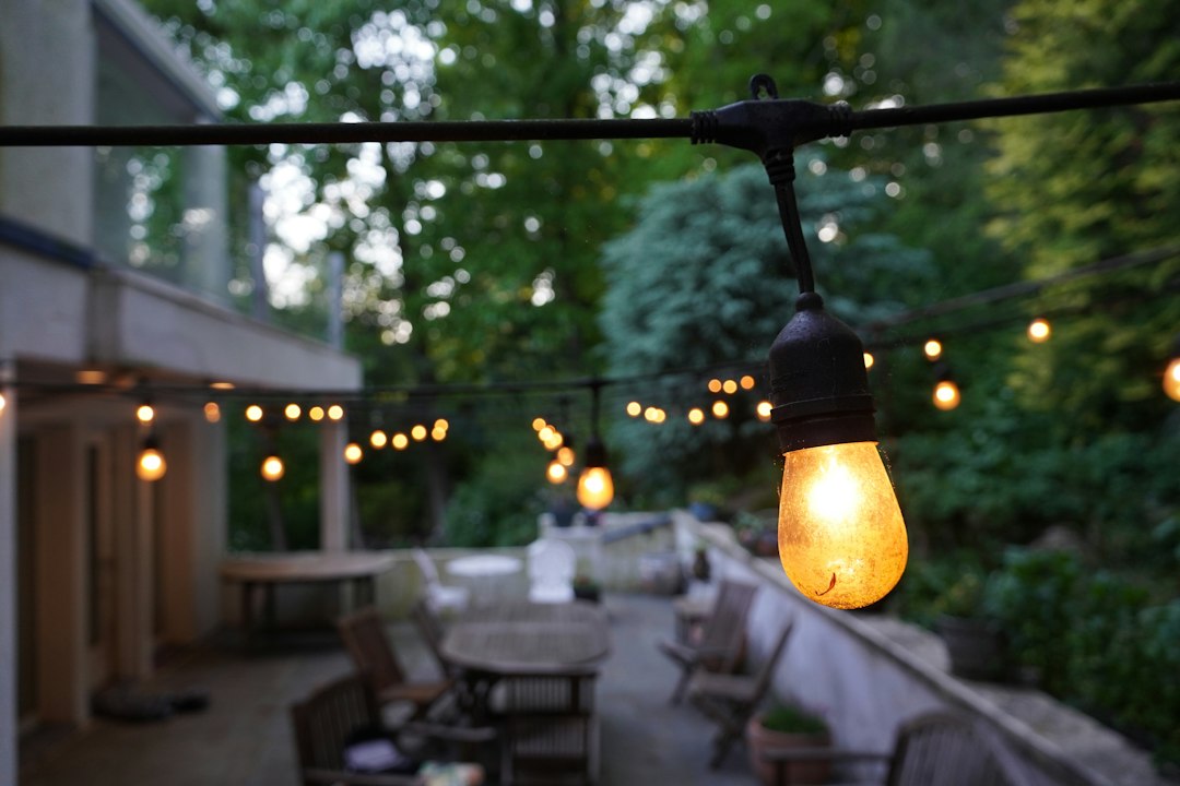 A suburban backyard patio glowing under string lights at dusk