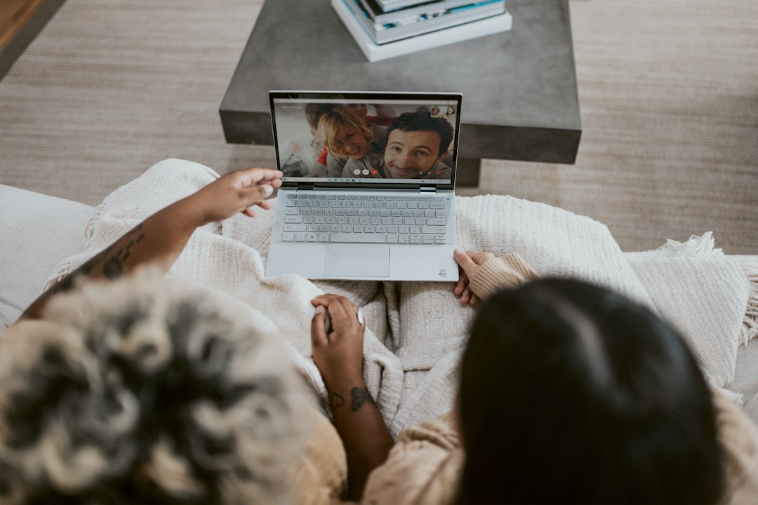Family on a couch having a video call on a laptop