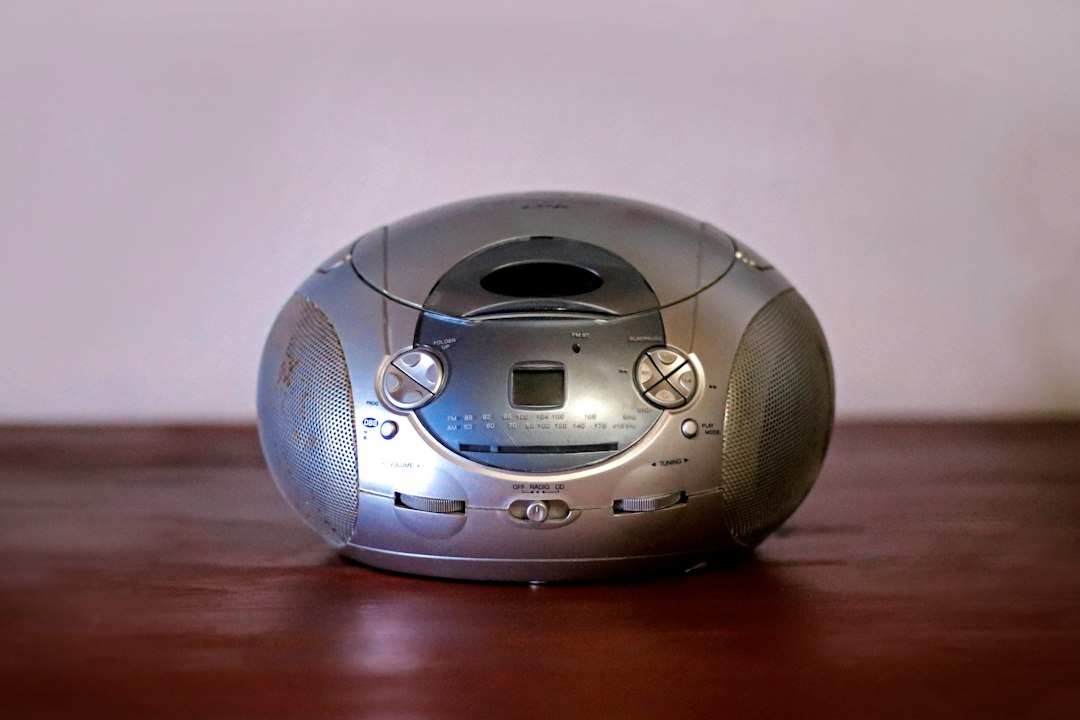 A portable CD and radio boombox sitting on a wooden surface