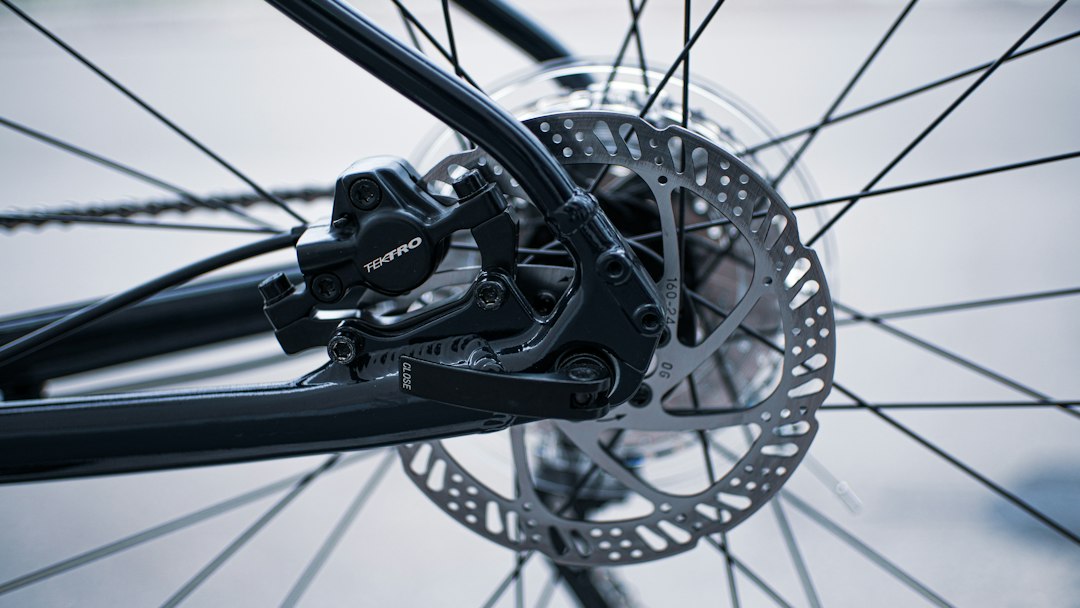 Close-up of a hydraulic disc brake caliper and rotor on a bicycle wheel
