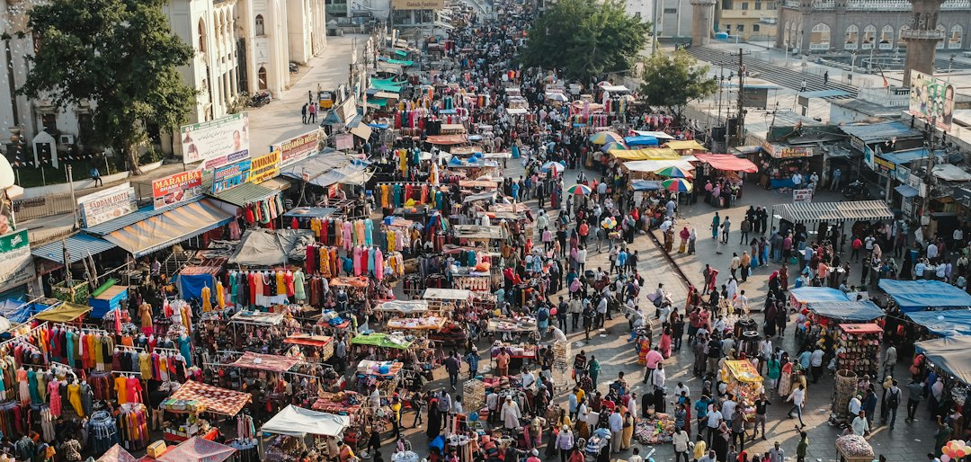 Crowd shopping among colorful stalls at a busy outdoor market