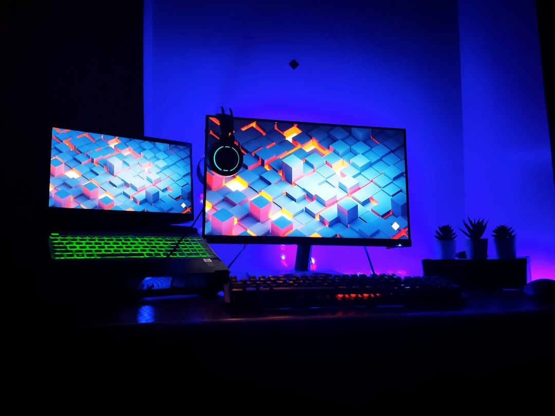 Gaming desk setup at night with a large curved monitor, RGB keyboard and purple ambient lighting